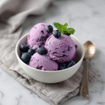Scoops of blueberry cottage cheese ice cream recipe served with fresh blueberries